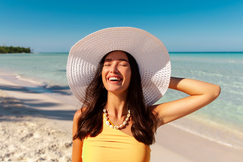 Smiling person standing on a sunny beach