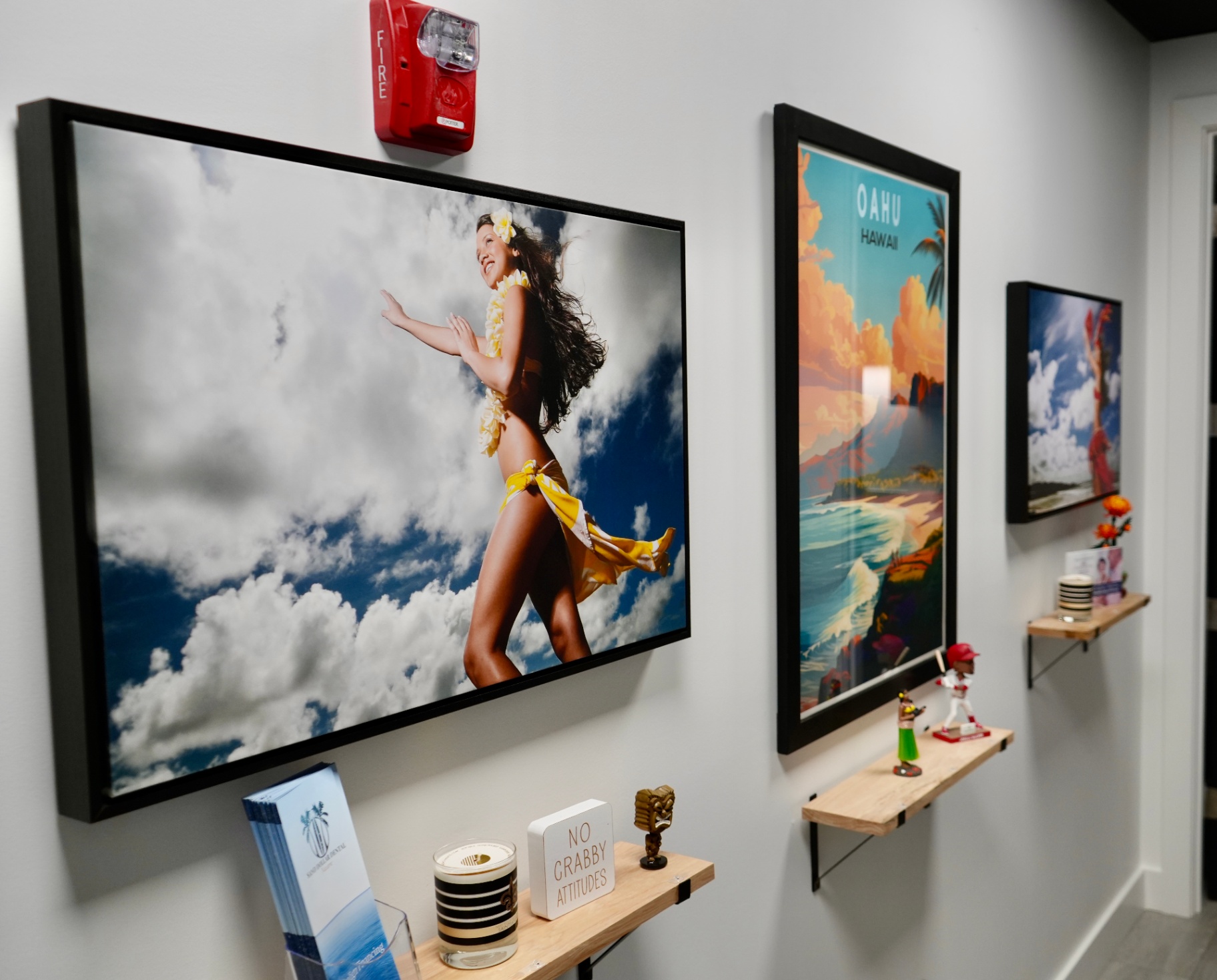 Hallway gallery wall with Hawaii-themed art and bobbleheads